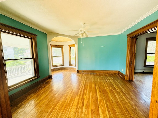 empty room featuring a baseboard radiator, hardwood / wood-style flooring, and ornamental molding