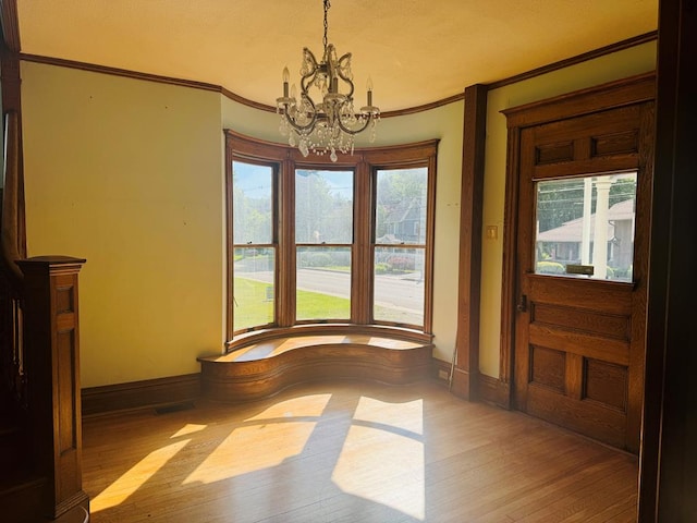 dining room with ornamental molding, light hardwood / wood-style floors, and a notable chandelier