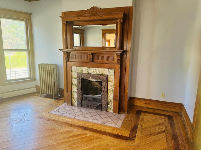 interior details featuring a tile fireplace, hardwood / wood-style flooring, radiator heating unit, and a baseboard heating unit