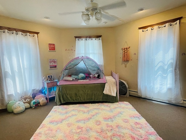 bedroom with carpet, ceiling fan, and baseboard heating