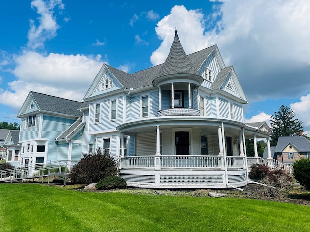 victorian-style house featuring a porch and a front yard