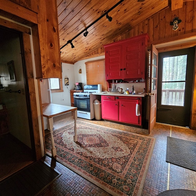 kitchen featuring red cabinetry, light countertops, vaulted ceiling, wooden ceiling, and gas stove