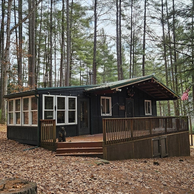 view of front of house featuring metal roof, a deck, and a sunroom