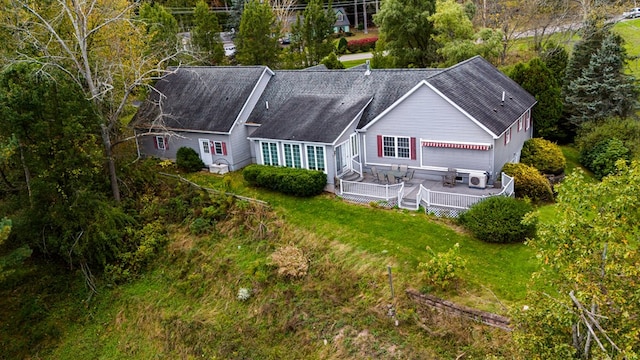 rear view of house with a wooden deck and a yard