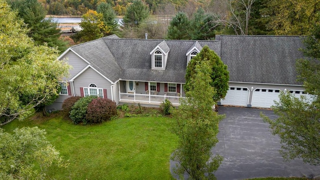 view of front of house featuring a garage, covered porch, and a front yard