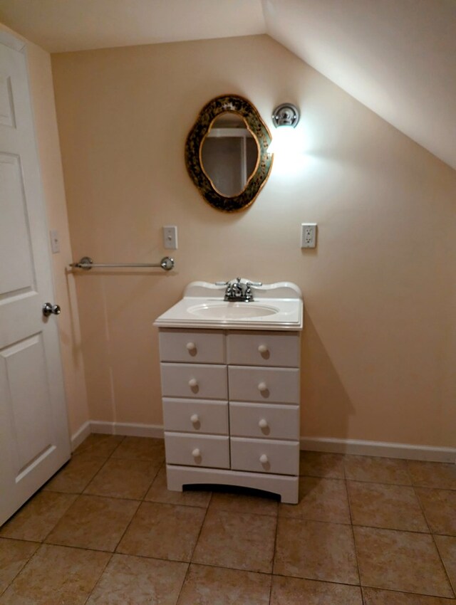 bathroom featuring tile patterned flooring, vanity, and lofted ceiling