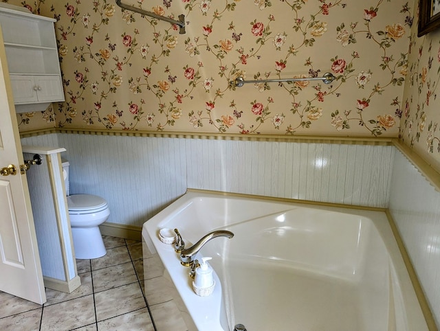 bathroom featuring tile patterned floors, a bathtub, and toilet