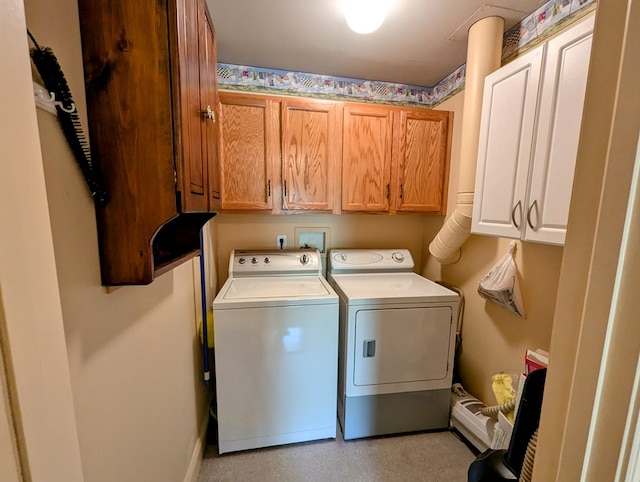 clothes washing area featuring cabinets and washing machine and dryer