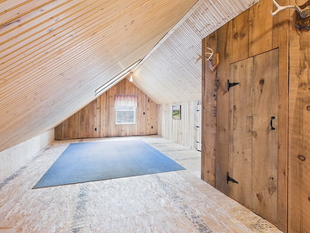 bonus room featuring vaulted ceiling and wooden walls