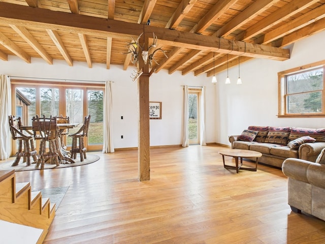 living area featuring wood ceiling, light wood-style floors, beamed ceiling, and baseboards