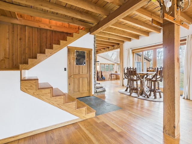 entrance foyer featuring wood ceiling, beamed ceiling, wood finished floors, and stairs