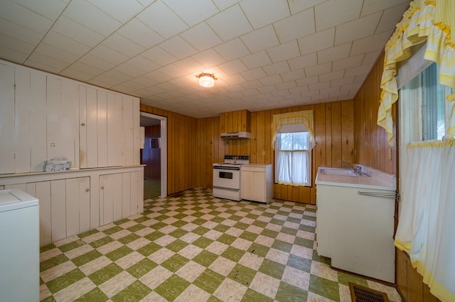 kitchen featuring light floors, electric range, light countertops, and washer / dryer