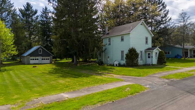 exterior space with a front yard, an outdoor structure, and a detached garage