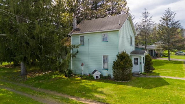 view of side of home featuring a lawn and a chimney