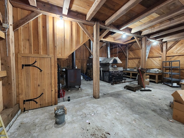 interior space featuring a wood stove and wooden walls