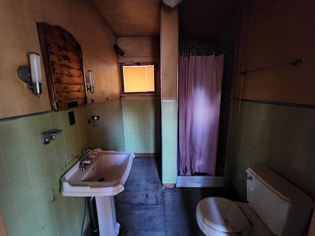 bathroom featuring a shower with curtain, tile walls, and toilet