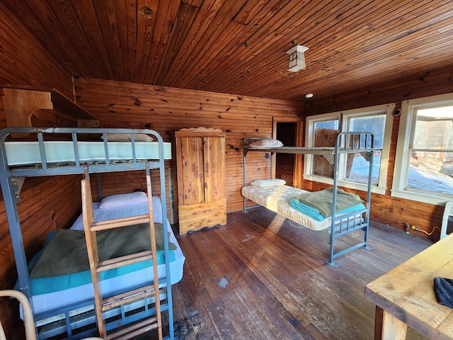 bedroom with wood-type flooring, wooden walls, and wood ceiling