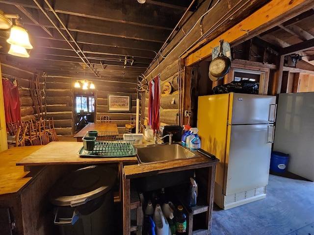 basement featuring white refrigerator and sink