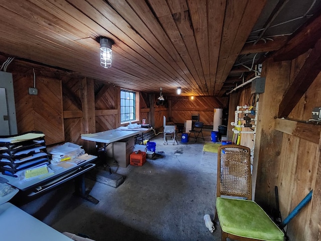 basement featuring electric panel, wooden ceiling, and wooden walls