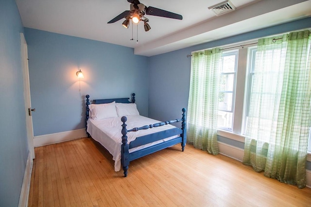 818 W Water St, Elmira, NY 14905 - bedroom featuring multiple windows, wood finished floors, baseboard heating, and a ceiling fan