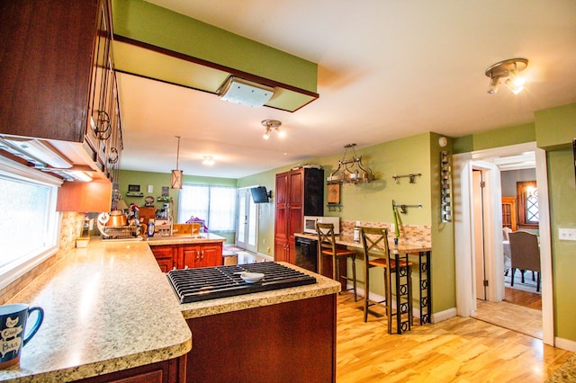 818 W Water St, Elmira, NY 14905 - kitchen featuring light countertops, light wood-type flooring, a peninsula, stovetop, and reddish brown cabinets