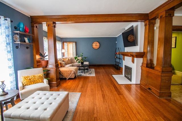 818 W Water St, Elmira, NY 14905 - living room featuring ornate columns, a fireplace, wood finished floors, and ornamental molding