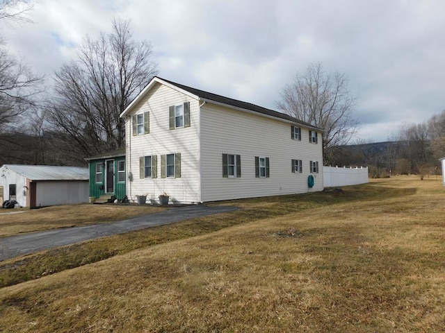 view of side of home with entry steps and a yard