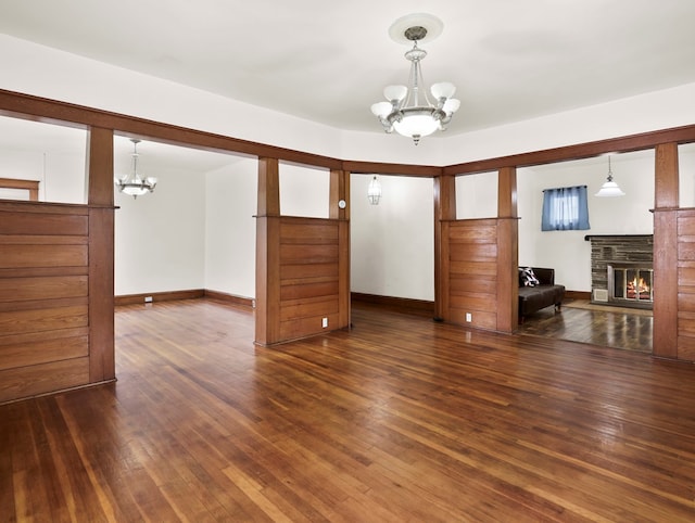 29 Cadwell Ave, Waverly, NY 14892 - empty room featuring a chandelier, a glass covered fireplace, wood finished floors, and baseboards
