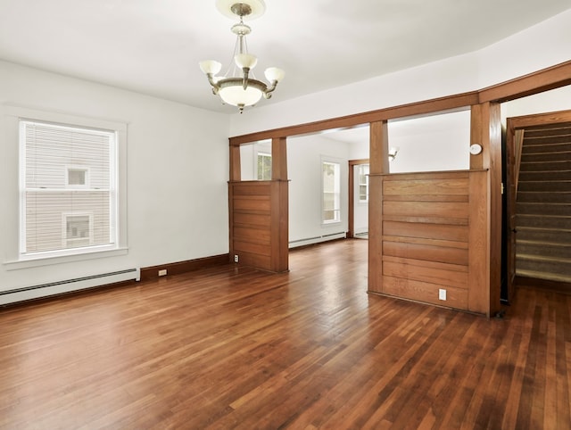 29 Cadwell Ave, Waverly, NY 14892 - empty room with a baseboard heating unit, a chandelier, dark wood-style flooring, and stairs