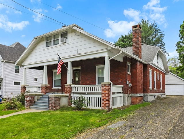 29 Cadwell Ave, Waverly, NY 14892 - bungalow-style house featuring covered porch, a chimney, an outdoor structure, a garage, and brick siding
