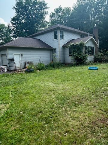 rear view of property with a yard and a garage