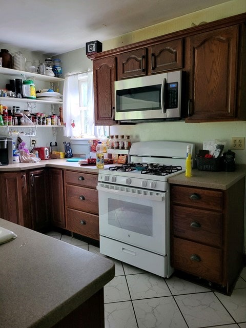 kitchen featuring dark brown cabinetry and white gas range