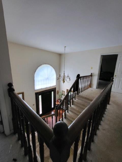 stairs featuring carpet and an inviting chandelier