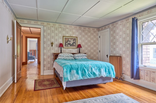 76 Front St, Owego, NY 13827 - bedroom featuring radiator heating unit, hardwood / wood-style floors, multiple windows, and wallpapered walls