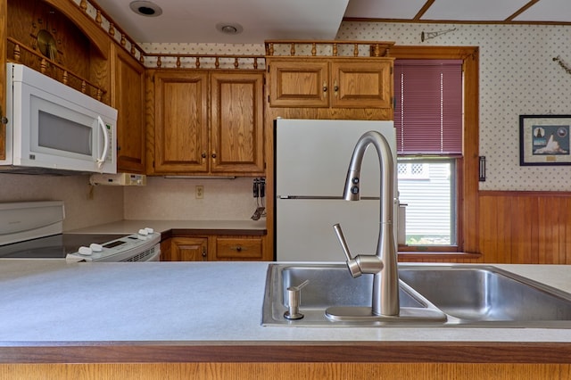 76 Front St, Owego, NY 13827 - kitchen featuring white appliances, a sink, brown cabinetry, light countertops, and wallpapered walls
