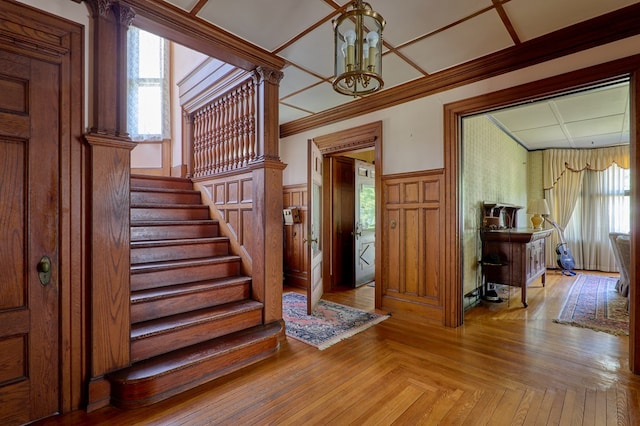 76 Front St, Owego, NY 13827 - foyer featuring a chandelier, stairway, a wainscoted wall, crown molding, and healthy amount of natural light
