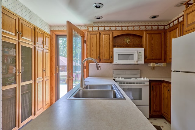 76 Front St, Owego, NY 13827 - kitchen featuring white appliances, a sink, wallpapered walls, light countertops, and brown cabinetry