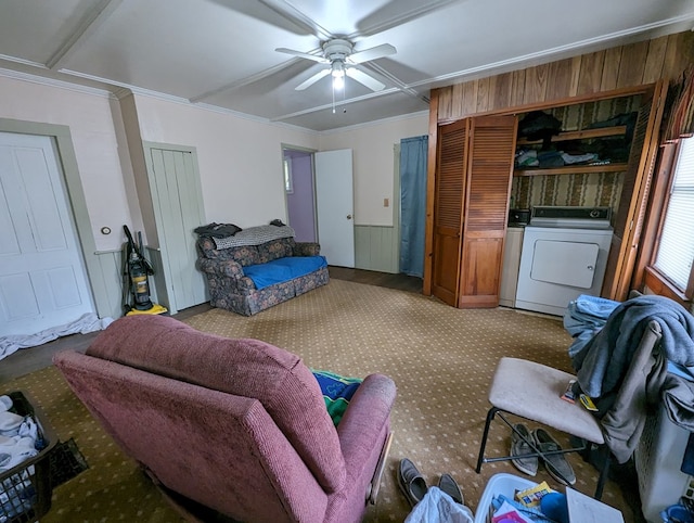 interior space featuring washer and clothes dryer, ceiling fan, wooden walls, and ornamental molding