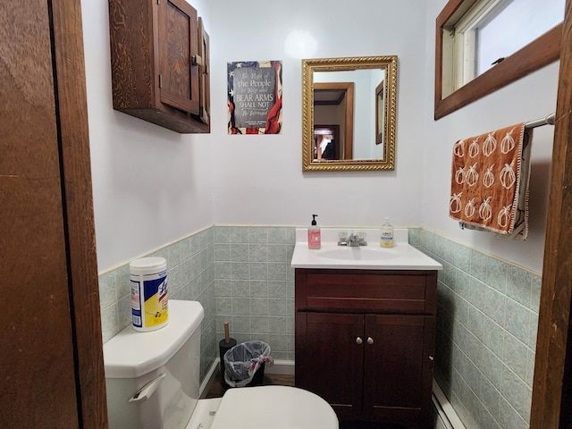 bathroom with vanity, toilet, and tile walls