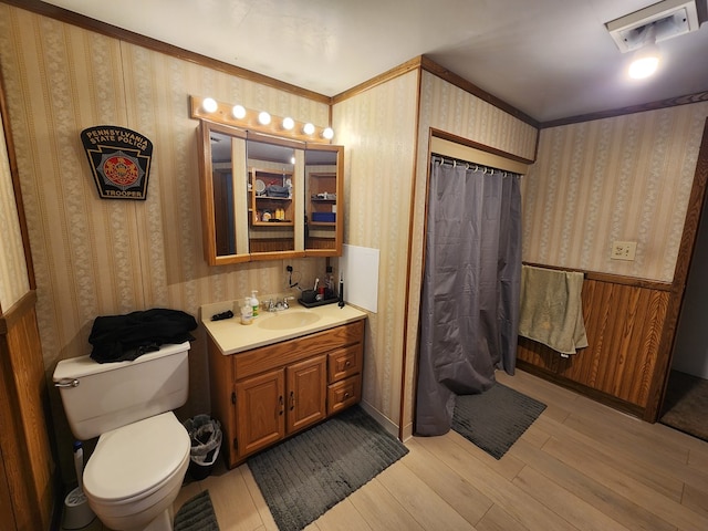 bathroom featuring hardwood / wood-style flooring, vanity, toilet, and curtained shower