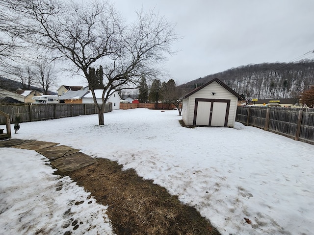 yard covered in snow with a storage unit