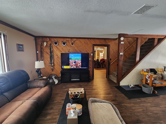 living room featuring crown molding, dark wood-type flooring, and a textured ceiling