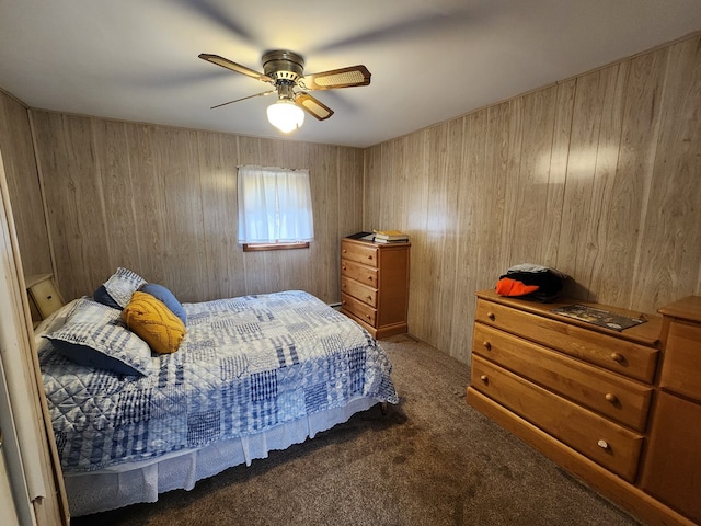 carpeted bedroom featuring ceiling fan and wood walls