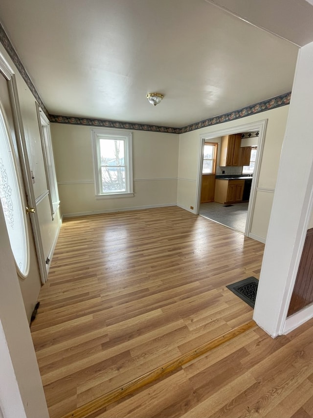 spare room with a healthy amount of sunlight and light hardwood / wood-style floors