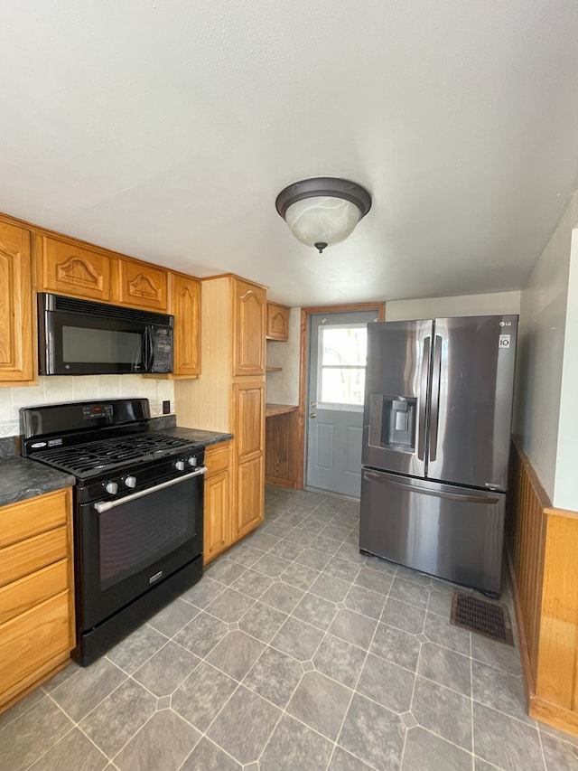 kitchen with wooden walls and black appliances