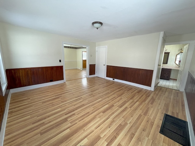 empty room featuring wooden walls and light wood-type flooring