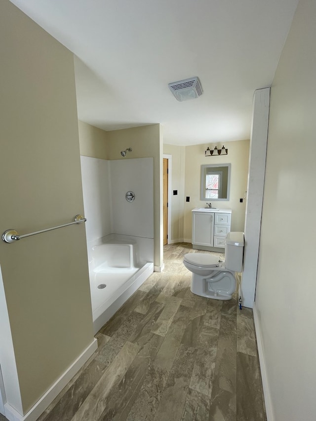 bathroom featuring vanity, a shower, and toilet