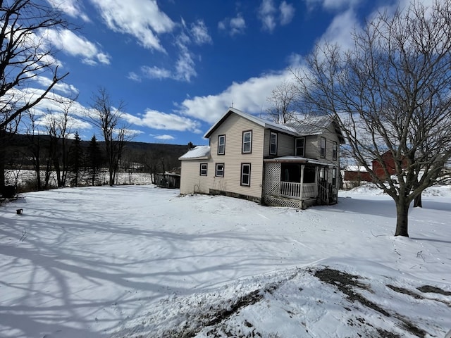 view of snow covered back of property