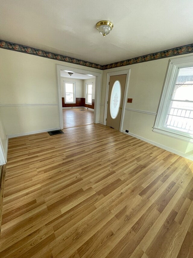 entrance foyer with plenty of natural light and light hardwood / wood-style flooring