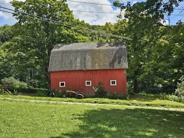 view of property exterior with a yard and an outbuilding